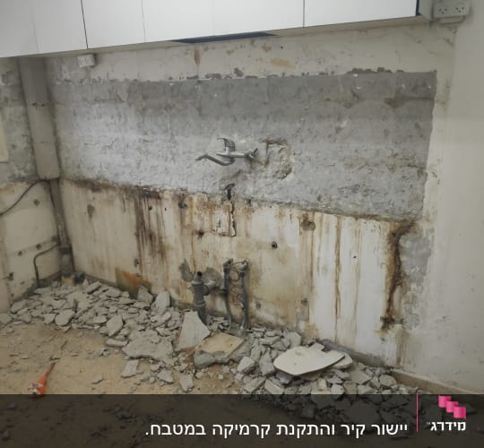 קיר חשוף עם צנרת, הריסות בטון על הרצפה